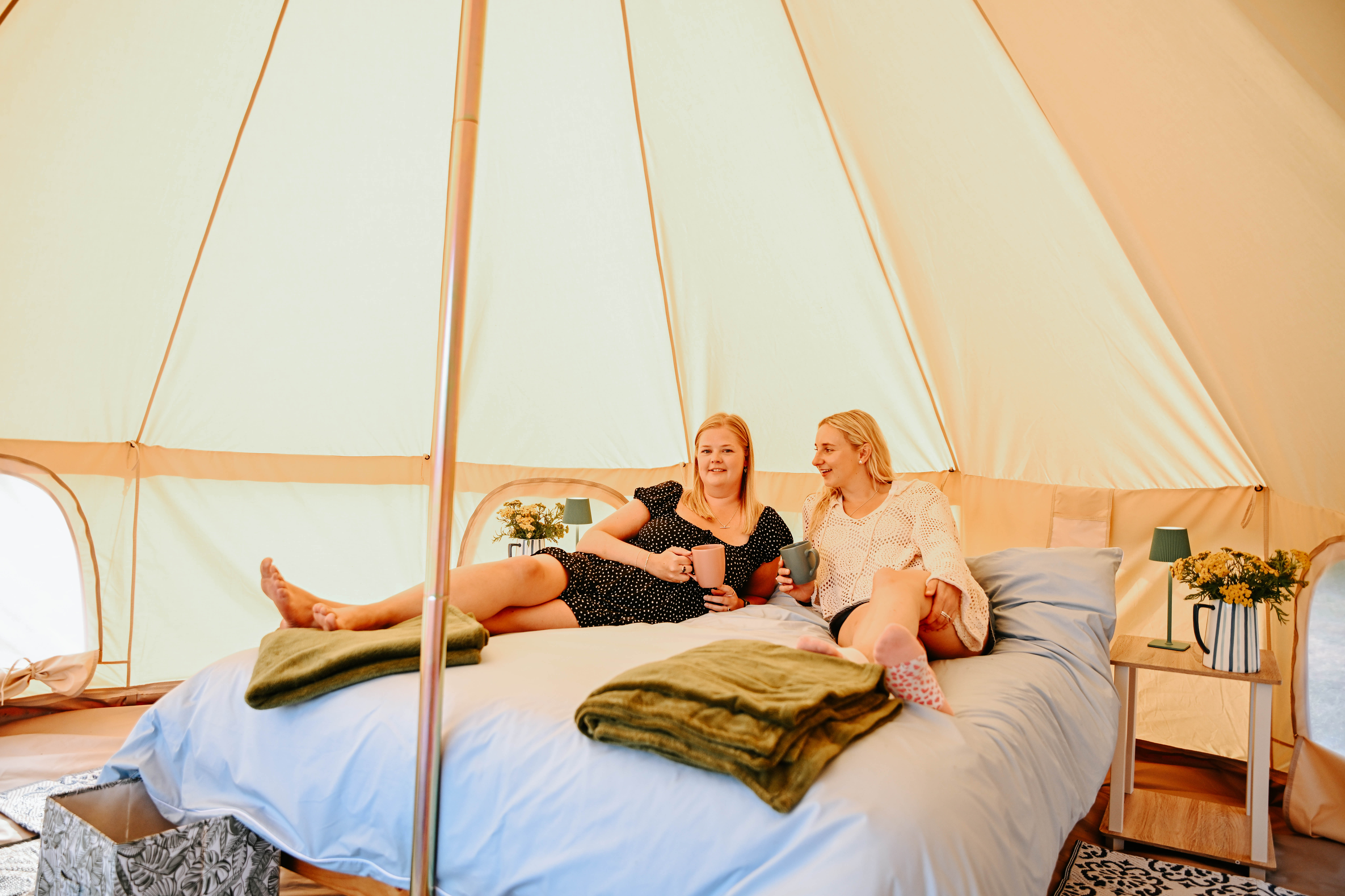 Inside a bell tent at Hopnest — relaxing on a king-size bed